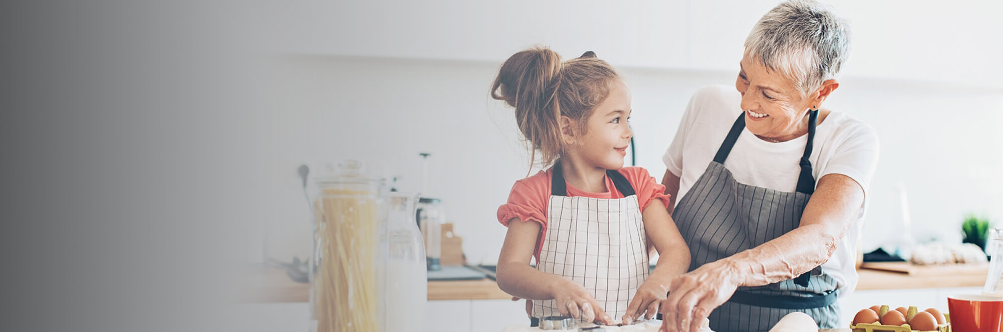 Grandmother making food with granddaughter