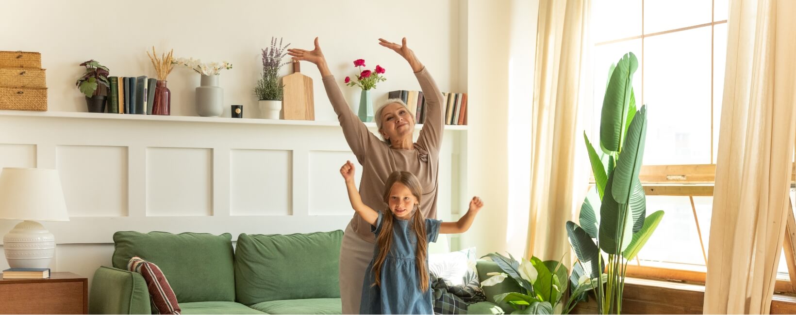 Grandmother and Granddaughter doing yoga poses in a living room